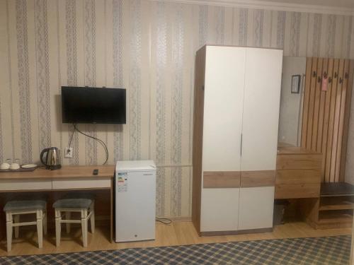 a room with a refrigerator and a desk with a television at Mim hotel in Magaldarkhan