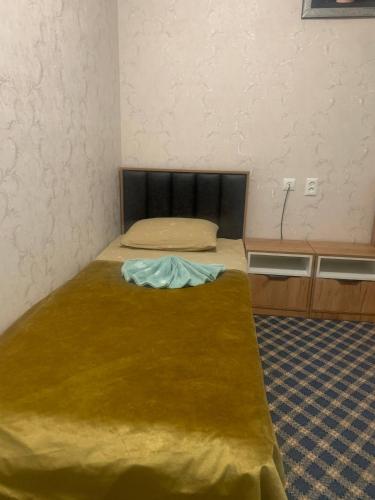 a small bedroom with a bed with a brown blanket at Mim hotel in Magaldarkhan
