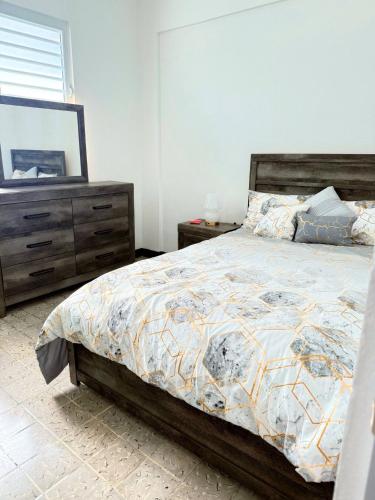 a bedroom with a bed with a dresser and a mirror at Charming 3BR Near Ponce Attractions in Ponce