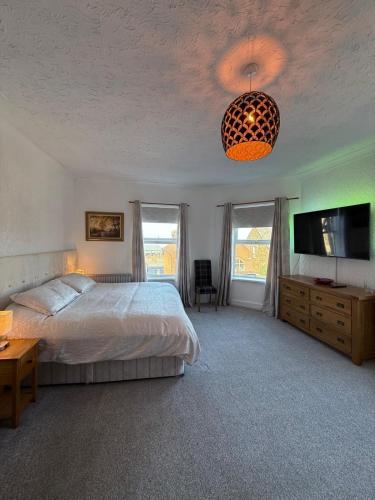a bedroom with a bed and a flat screen tv at Crispin House in Hunstanton