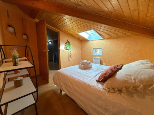 a bedroom with a bed with a wooden ceiling at Gîte Le 1935 Évasion en Ardèche, au cœur de la campagne, idéal pour balades à vélo et moto in Saint-Sylvestre