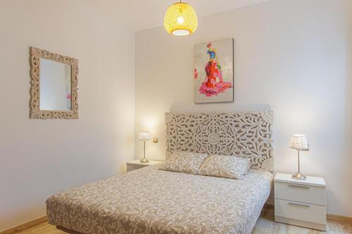a bedroom with a bed and two lamps and a mirror at Cotillo Jolanda in El Cotillo