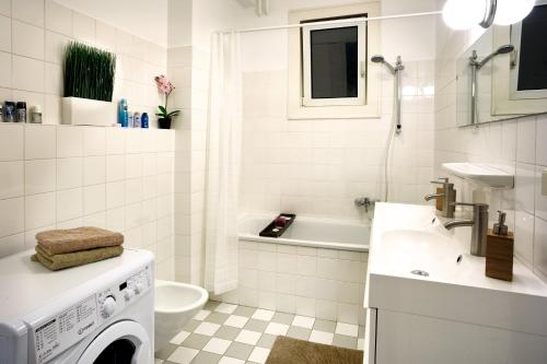 a white bathroom with a washing machine and a sink at OPERASTREET CITY CENTER Apartment "Bangkok" in Vienna in Vienna