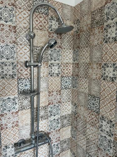 a shower in a bathroom with a tile wall at Apartment Le Forge in Policoro