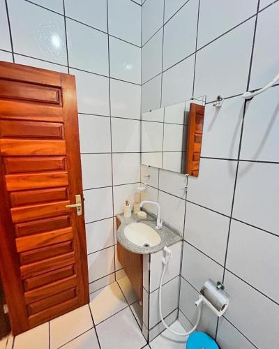 a small bathroom with a sink and a mirror at Beach House Suítes Jeri in Jericoacoara