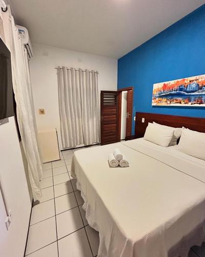 a bedroom with a large bed with two shoes on it at Beach House Suítes Jeri in Jericoacoara