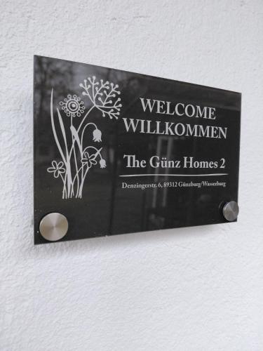 a sign on a wall with flowers on it at The Günz Homes 2 in Günzburg