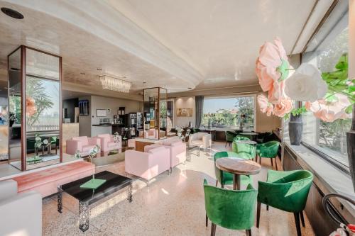 ein Wohnzimmer mit rosa und grünen Stühlen in der Unterkunft Antony Hotel - Venice Airport in Campalto