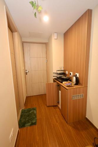 a small room with a kitchen with a counter and a door at Sunleaf Studio Pari Chawk Expo Mart in Greater Noida