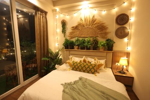 a bedroom with a bed with plants on the wall at Sunleaf Studio Pari Chawk Expo Mart in Greater Noida