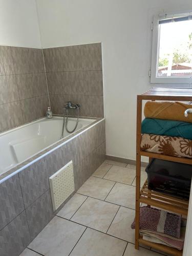 a bathroom with a tub and a tile floor at Case Géranium 2* piscine chauffée in Saint-Joseph