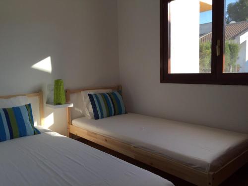 two beds in a room with a window at Casa Azul in Riumar