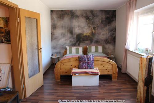 a bedroom with a wooden bed and a painting on the wall at Appartement Erzgebirge in Schönheide