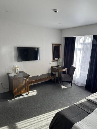 a hotel room with a bed and a desk and a television at Optima Collection Bergshloss Rivne in Rivne