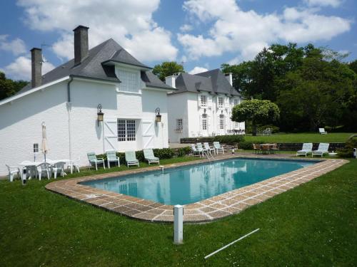 a house with a swimming pool in front of a building at Clos Mirabel Manor - B&B in Jurançon