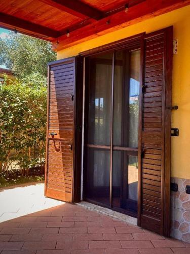 an open wooden door of a house with a patio at Casa Malò 2 in Ovile la Marinella