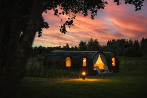 a tent with a table and a chair in a field at Estate Cabins at Ballygarry in Tralee