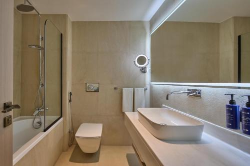 a bathroom with a sink and a toilet and a shower at Radisson Blu Residence, Dubai Marina in Dubai