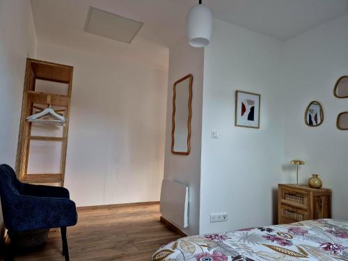 a bedroom with a bed and a blue chair at le St fursy 31 in Péronne