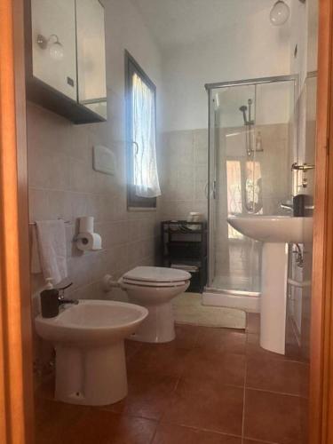 a bathroom with a toilet and a sink at Casa Malò 2 in Ovile la Marinella