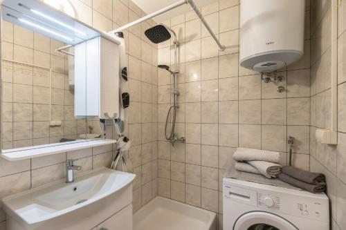 a bathroom with a sink and a washing machine at Sweet Escape in Makarska