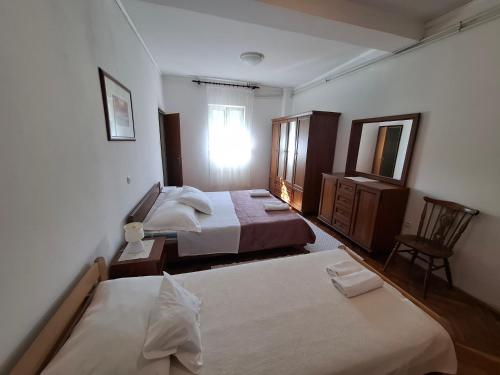 a bedroom with two beds and a dresser and a mirror at Marija šimičić in Rab