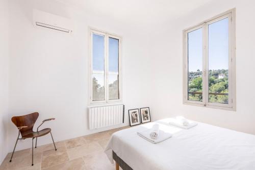 a white room with a bed and a chair at House on the Hill in Nice