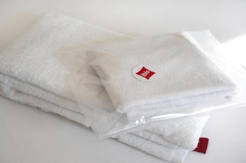 a stack of white towels with a red sticker on them at Hotel Ibis Coimbra Centro in Coimbra
