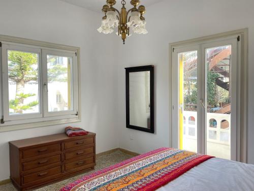 a bedroom with a bed and a dresser and windows at Lulus Kastri in Keratokampos