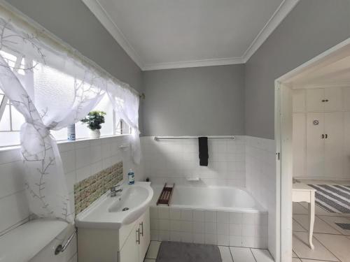 un bagno bianco con vasca e lavandino di 208 On Circular a Lorraine