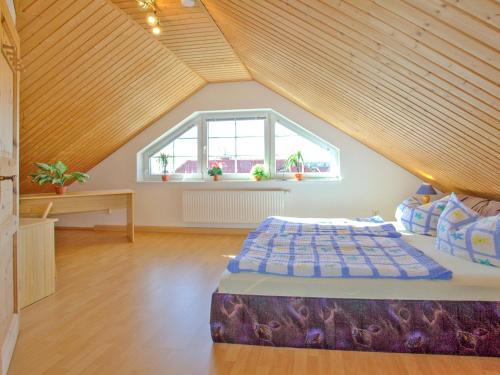 a attic room with a bed and a window at Villa Lisa in Glowe
