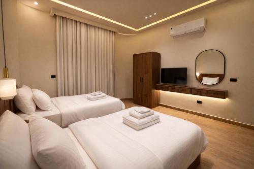 a hotel room with two beds and a television at Cairo Stays Hotel in Cairo