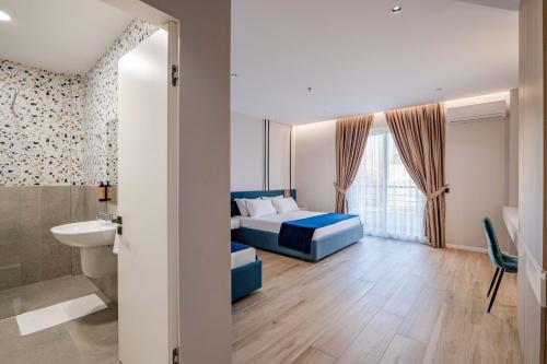 a bedroom with a blue bed and a bathroom at Hotel Vino in Durrës