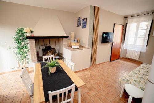 a kitchen and living room with a table and a fireplace at Aura Apartment - VISTA LAGO - CENTRO STORICO in Bracciano