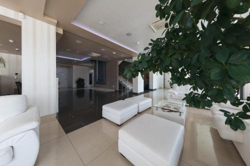 a living room with white furniture and a plant at Hotel Villa Pace in Međugorje