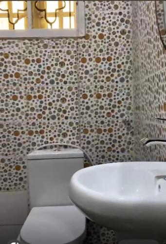 a bathroom with a toilet and a sink and a mirror at Living Space Home in Lekki