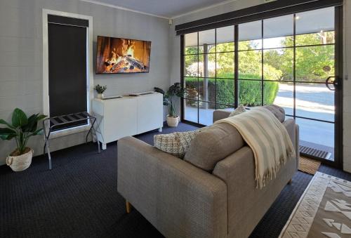 a living room with a couch and a large window at Chandelle Park Farm Stay in Exeter