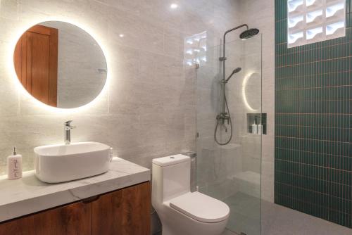 a bathroom with a toilet and a sink and a shower at Villa Chandra Lovina in Lovina