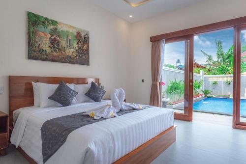 a bedroom with a large bed and a pool at Villa Chandra Lovina in Lovina