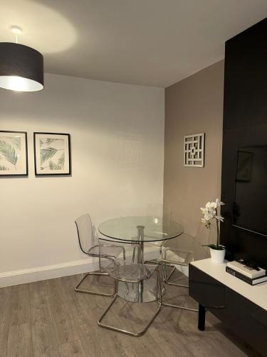 a dining room with a glass table and chairs at Beautifully Designed Pollok House in Glasgow