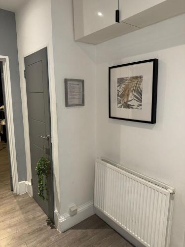a hallway with white walls and a picture on the wall at Beautifully Designed Pollok House in Glasgow