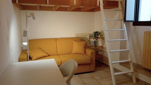 a living room with a yellow couch and a ladder at Palmieri Cozy Stay in Monopoli