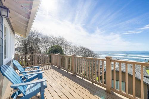 two blue chairs sitting on a deck looking at the ocean at Annie's Windsong in Lincoln City