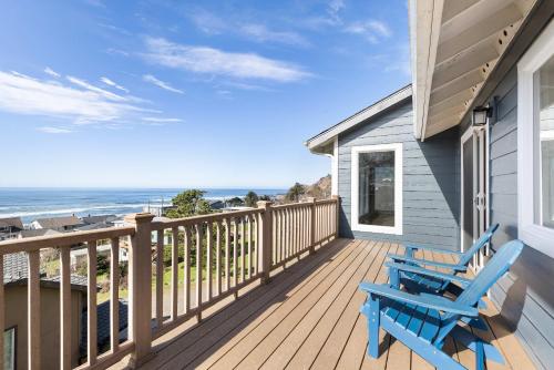 a deck with a blue bench and the ocean at Annie's Windsong in Lincoln City