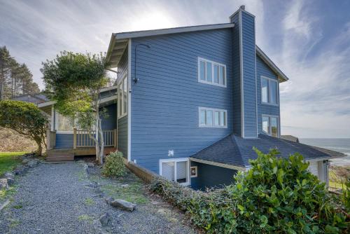 a blue house with the ocean in the background at Annie's Windsong in Lincoln City