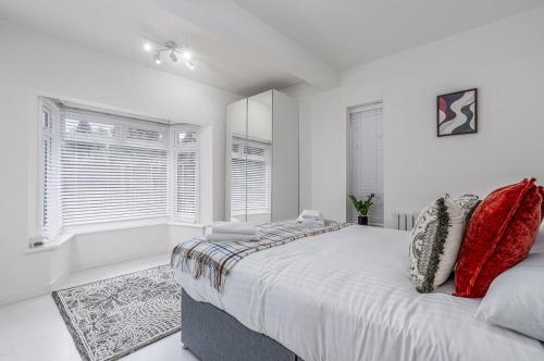 a white bedroom with a large bed and a bath tub at Modern 2-Bed Sleeps 5 Free Parking and Wifi near Stansted and London in Bishops Stortford