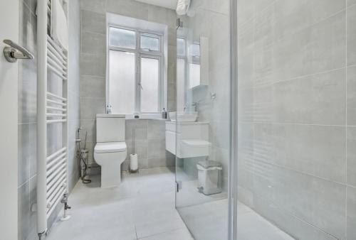 a bathroom with a toilet and a sink and a shower at Modern 2-Bed Sleeps 5 Free Parking and Wifi near Stansted and London in Bishops Stortford