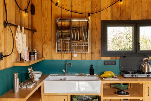 a kitchen with a sink and a window at Bon Air Club in Saint-Léonard-des-Bois