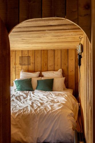 a large bed with a wooden headboard and pillows at Bon Air Club in Saint-Léonard-des-Bois
