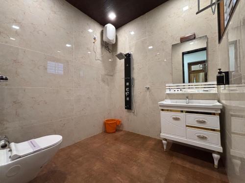 a bathroom with a sink and a toilet and a mirror at Èden Ember Castle in Gokarna